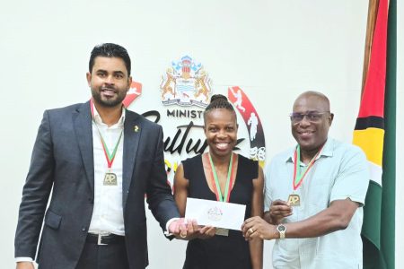 Minister Charles Ramson Jr. (left) and Director of Sport Steve Ninvalle make the Government of Guyana’s presentation of $7M to AP Invitational Organiser Aliann Pompey.
