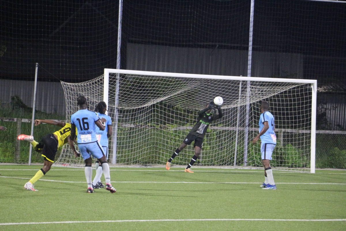 Samuel Garnette (yellow) of Western Tigers is denied by the Anns Grove goalkeeper
