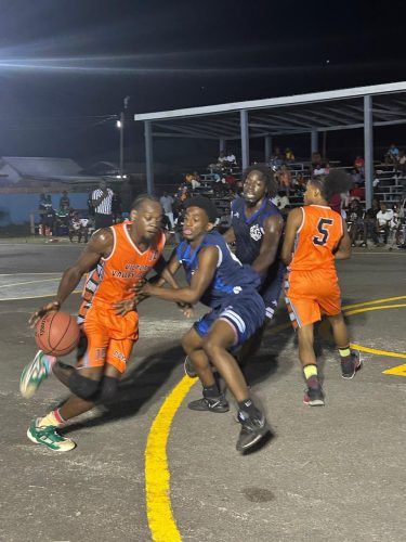 Harold Adams (left) of the Victory Valley Royals is in the process of driving to the hoop while being challenged by an Amelia’s Ward Jets player