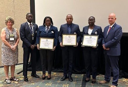 Members of the Guyana Police Force Training Academy posing with the International Accreditation certificates for the three training centres in Guyana, at the IADLEST Conference in Arizona, From left are: IADLEST Kelly Alzaharma; Assistant Superintendent Gladwin Hanover; Superintendent Sonia Herbert; Deputy Commissioner – Administration - Calvin Brutus;   GPF Superintendent Nicola Kendall, and IADLEST President Mike Ayers. (US Embassy photo)

