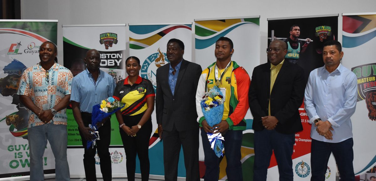 Carlos Petterson-Griffith (3rd from right) was honoured upon his return to local shores yesterday morning. Also in the photo are Director of Sport Steve Ninvalle (2nd from right), GAPLF President Franklin Wilson (4th from right), and former record holder Winston Stoby (2nd from left) (Zaheer Mohamed photo).
