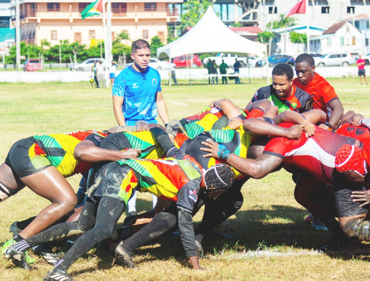 The referee watches on as Guyana (green) and Trinidad and Tobago lock horns in a scrum at the Guyana Defence Force Ground, Camp Ayanganna.