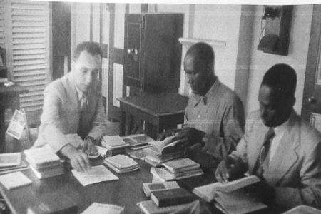 CID sleuths and Sir David Rose (left) perusing seized “Marxist”
documents from the PPP in 1953 