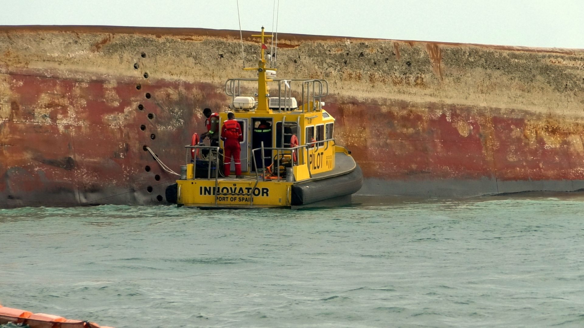 Workmen at the overturned Gulfstream barge off Cove, Tobago, in February.