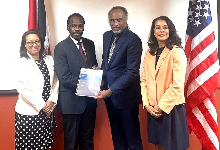 Eastern and Southern Caribbean US Agency for International Development (USAID) regional representative Mervyn Farroe, second right, presents Minister of National Security Fitzgerald Hinds with a copy of USAID’s Reports on Gang Violence in T&T during a meeting at the ministry in Port-of-Spain on Monday. Looking on are US Ambassador to T&T Candace Bond, right, and Permanent Secretary in the Ministry of National Security Natasha Barrow.