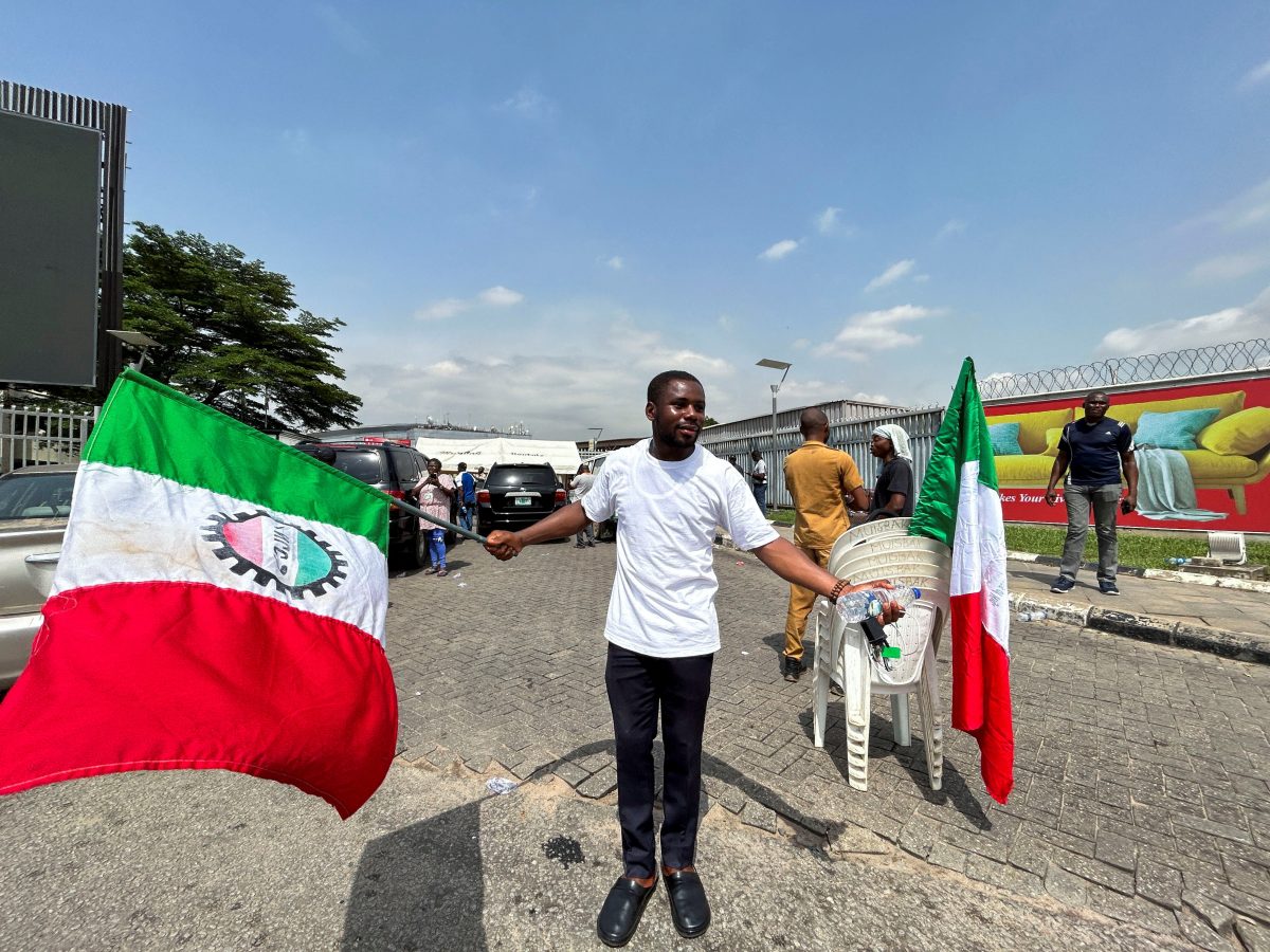 A member of the Nigeria Labour Congress dances in front of the domestic airport which has been shut down as Nigeria’s main labour unions called for an indefinite strike from Monday after failing to agree to a new minimum wage with the government, in Lagos, Nigeria. June 3, 2024.REUTERS/Seun Sanni