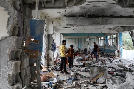 FILE PHOTO: Palestinians inspect the site of an Israeli strike on a UNRWA school sheltering displaced people, amid the Israel-Hamas conflict, in Nuseirat refugee camp in the central Gaza Strip, June 6, 2024. REUTERS/Abed Khaled/File Photo