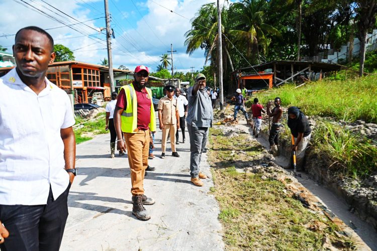 Prime Minister Mark Phillips (pointing) overseeing flood relief work in Linden on Thursday. (Office of the Prime Minister photo)