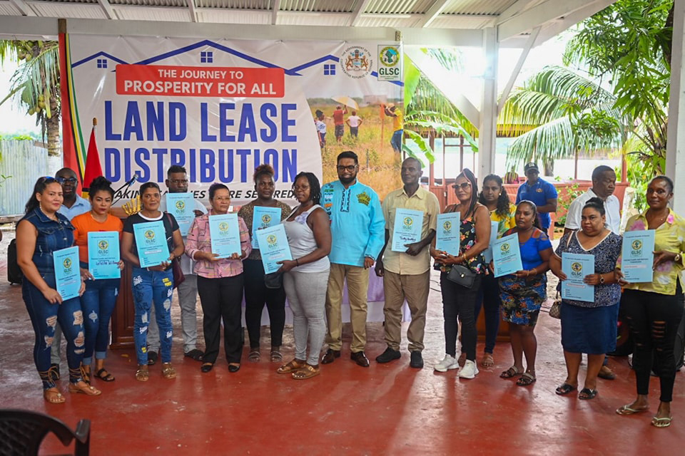  Over 400 residents of Base Road, Timehri; Swan Turn; Kuru Kururu, and surrounding communities yesterday received their land titles. President Irfaan Ali and Minister within the Office of the Prime Minister with responsibility for Public Affairs, Kwame McCoy, distributed the titles during a ceremony at Base Road, Timehri. In this Department of Public Information photo, President Irfaan Ali is at centre with some of the recipients.
