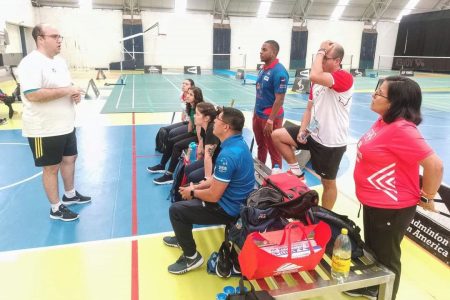 Coach Nkosi Beaton (3rd from right, standing) pays attention during a training session