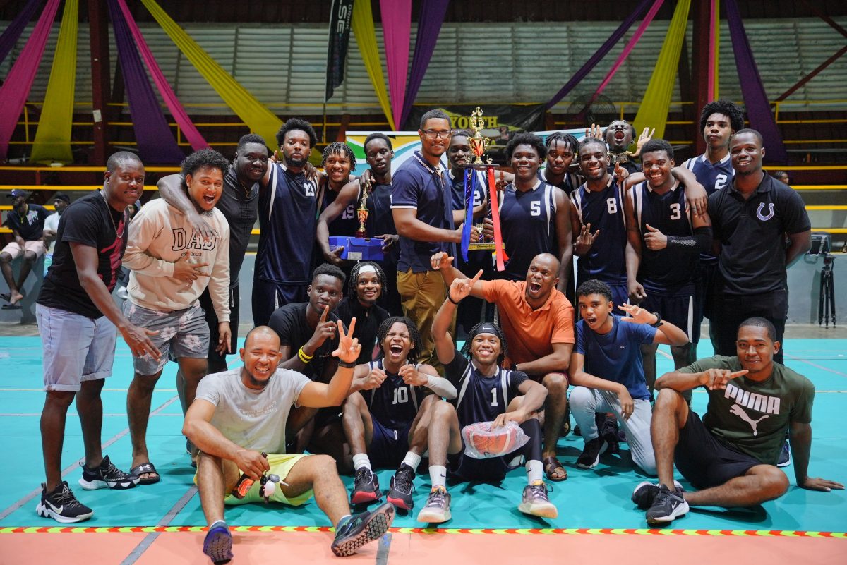 GABA President Jermaine Slater  presents the
championship trophy to the victorious Colts unit that defeated Kwakwani in the final of the Men’s U-23 Basketball Championship