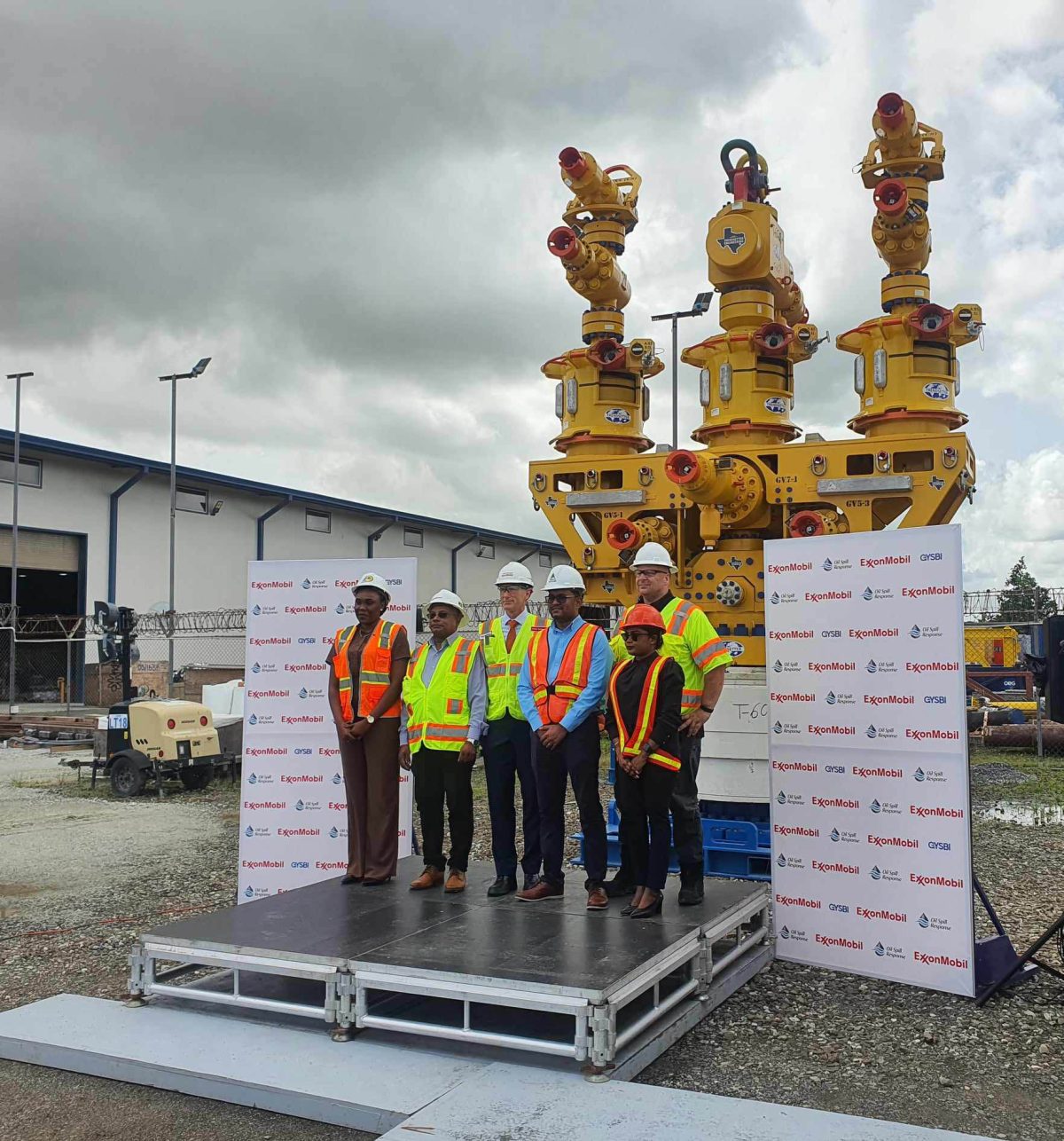 ExxonMobil’s Country President Alistair Routledge flanked by representatives of the Environmental Protection Agency and the  Civil Defence Commission in front of the capping stack, yesterday at GYSBI.  