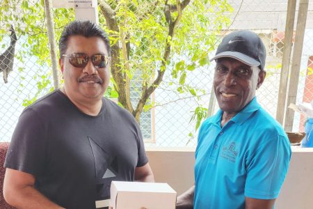 Anil Beharry (left), a representative of the ‘Cricket Gear for Young and Promising Cricketers in Guyana’ project, receives the three boxes of balls from former national cricketer David Harper on behalf of the Derek Kallicharran and the Kaiteur Club