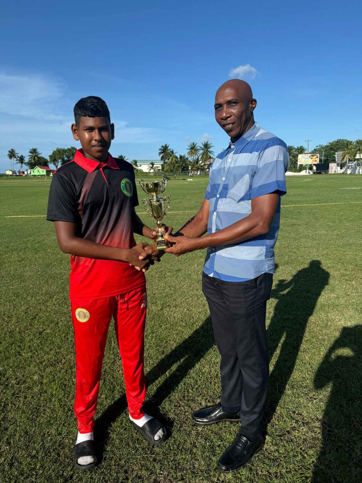 Romario Ramdehol (left) accepts his man-of-the-match prize from Shaun Massiah
