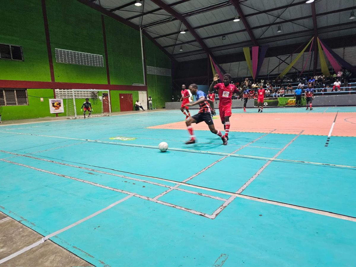 Daniel Wilson (yellow) of Western Tigers is in the process of attempting a long ball against Den Amstel in the KFC Elite League.