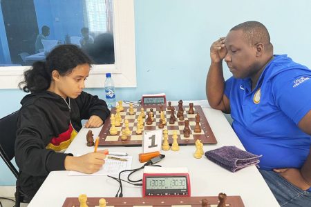 Ronuel Greenidge (right) winner of the 4th Grand Prix chess tournament, played undefeated. Aditi Joshi of Queen’s College is his opponent in this photo. 