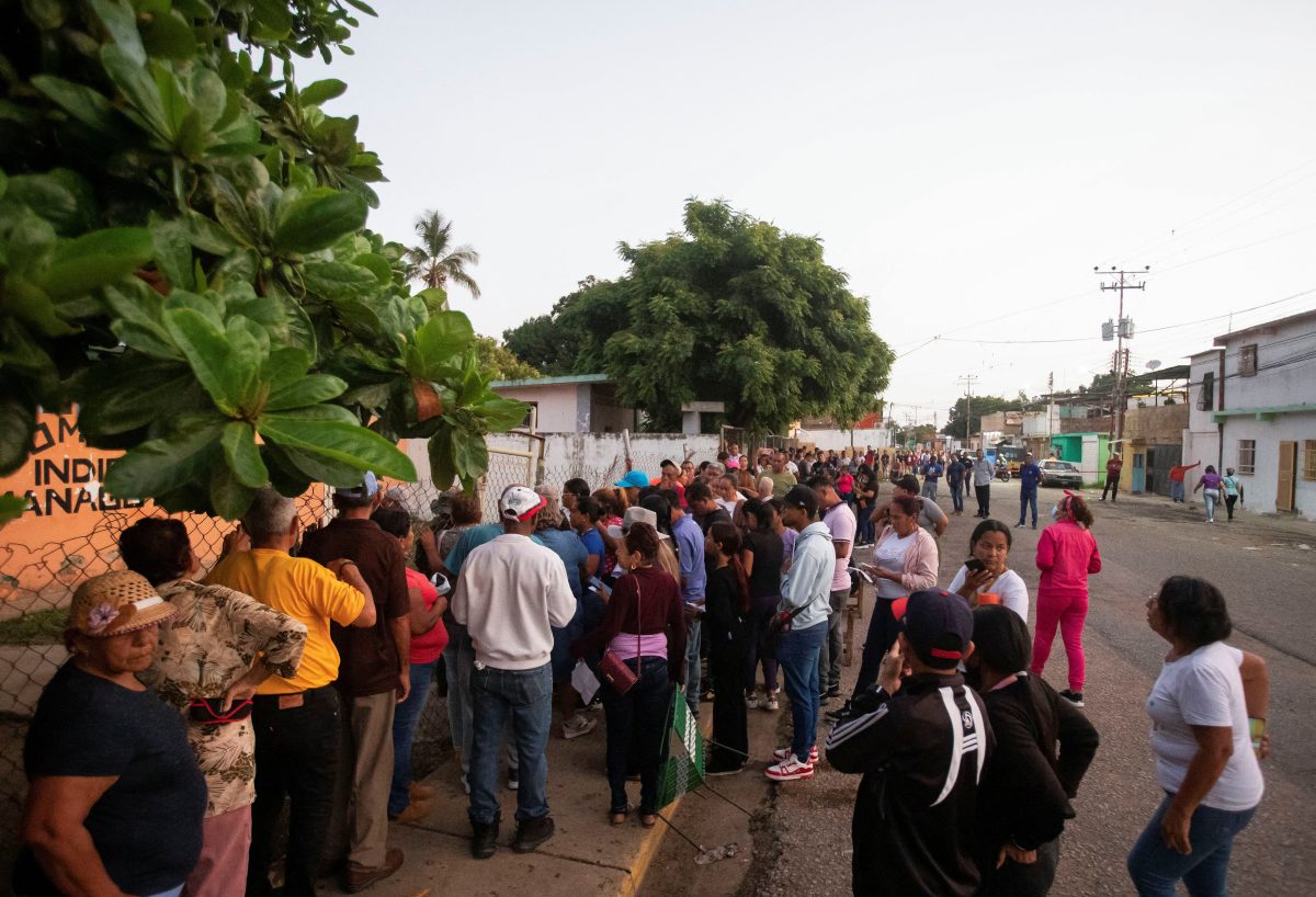 People stand in line outside a polling station to cast their votes in Venezuela’s presidential election, in Barcelona, Venezuela July 28, 2024. REUTERS/Samir Aponte