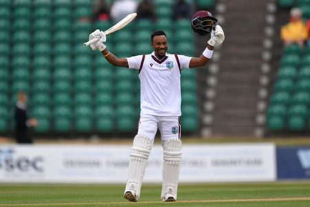 Kavem Hodge acknowledges his teammates upon reaching his century