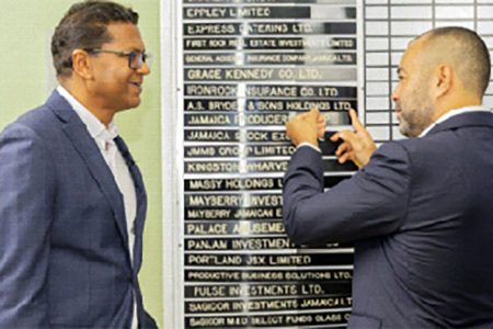 Nicholas Scott (right) a director of A.S Bryden places the company's name on the JSE listing board as CEO Richard Pandohie (left) looks on.