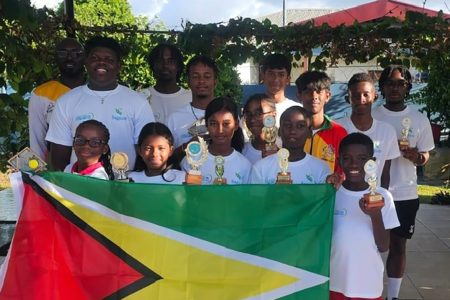 Team Guyana posing with their respective individual and doubles trophies following the conclusion of the SAGICOR Junior Tennis Championship in Trinidad and Tobago