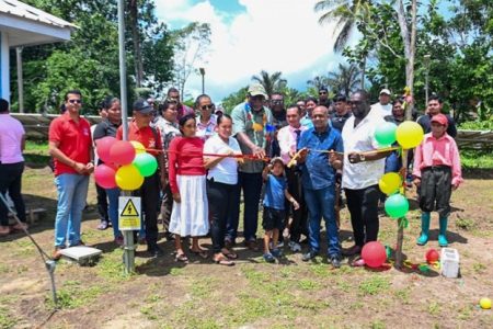 The grid at Canal Bank, costing $19.285 million, comprises 12 kilowatts of solar arrays, and a battery power of 35 kilowatts. It will benefit the lives of the 1200 residents.  Prime Minister Mark Phillips cutting the ibbon with residents of Sebai, Matarkai Sub-district, Region One to commission the Solar Photovoltaic Mini-Grid System in the community (DPI photo)