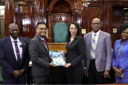 Speaker Manzoor Nadir (second from left) and PPC Chairperson, Pauline Chase, displaying a copy of the Annual Report
