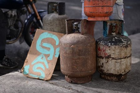 A man stacks gas canisters in a street stall, as Venezuela prepares for presidential elections, in Caracas, Venezuela July 20, 2024. REUTERS/Gaby Oraa/File Photo 