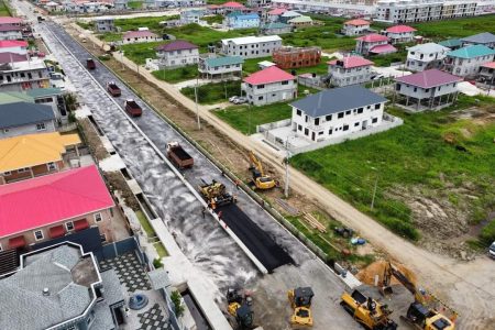 Paving has begun on the four-lane interconnection (Red Road) between the East Bank Public Road and Heroes Highway. (Office of the President photo).