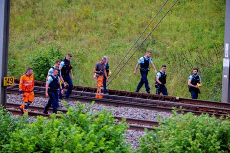 SNCF railway workers and police officers walk at the site where vandals targeted France's high-speed train network with a series of coordinated actions that brought major disruption, ahead of the Paris 2024 Olympics opening ceremony, in Croisilles, northern France July 26, 2024. (Reuters/Brian Snyder)