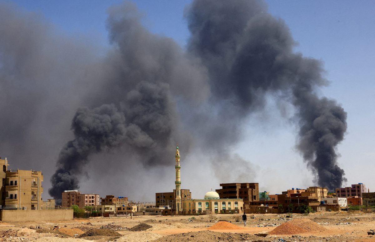 FILE PHOTO: A man walks while smoke rises above buildings after aerial bombardment, during clashes between the paramilitary Rapid Support Forces and the army in Khartoum North, Sudan, May 1, 2023. REUTERS/Mohamed Nureldin Abdallah//File Photo