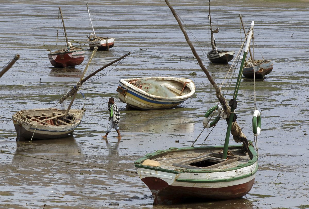 A fisherman walks toward his boat during low tide, in Maputo, September 28, 2010. REUTERS/ Goran Tomasevic/File Photo