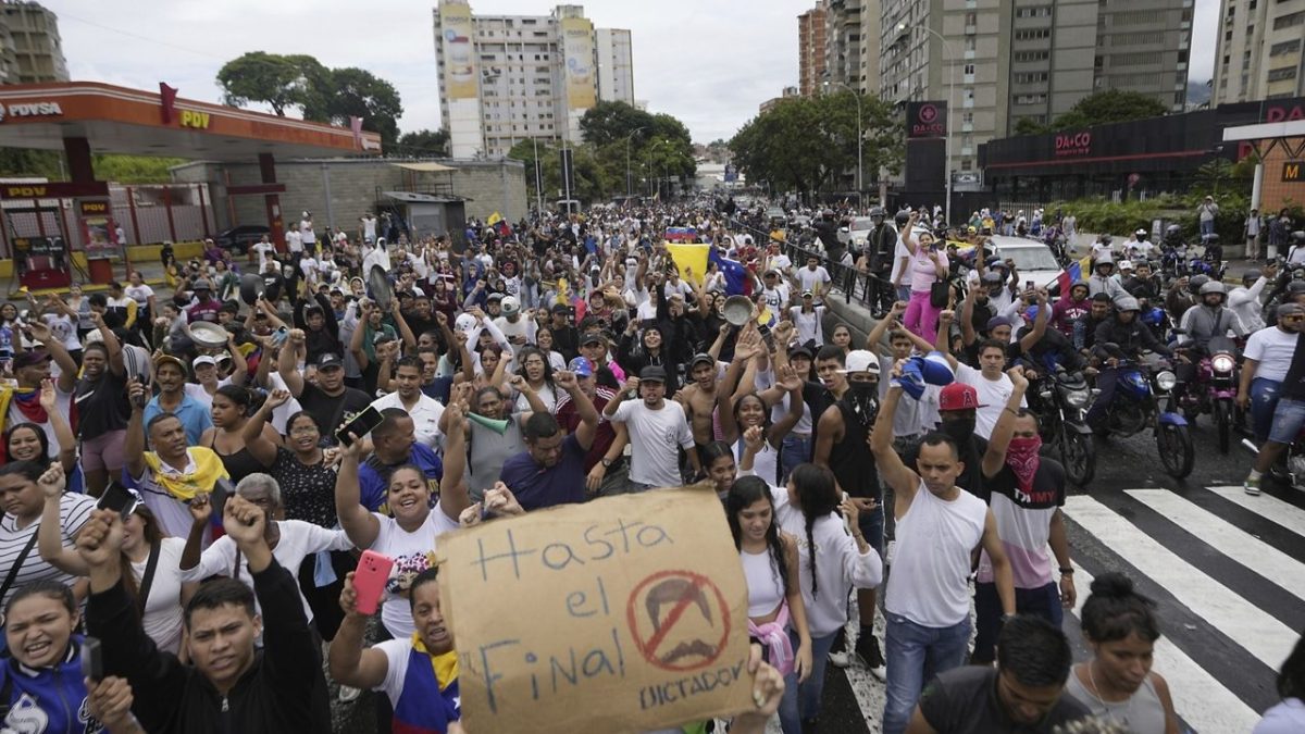 Protesters march against the official election results declaring President Nicolas Maduro the winner, the day after the presidential election in Caracas, Venezuela, Monday, July 29, 2024. The sign reads in Spanish “Until the end. No dictator.” (AP Photo/Matias Delacroix)