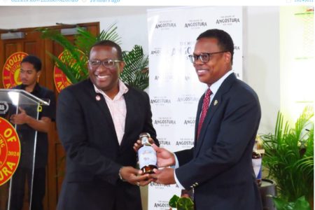 COO Angostura Ian Forbes  (left) present Minister of Foreign Caricom Affairs Amery Browne with a
bottle of the specially produced Caricom rum.