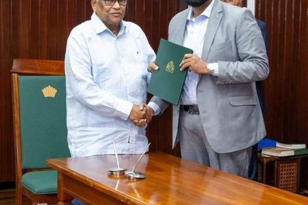 Dr Nanda Kishore Gopaul (left)  receiving his instrument of appointment from President Irfaan Ali (Office  of the President photo)