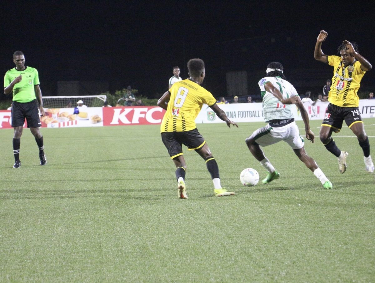 Kelsey Benjamin (centre) is trying to maintain possession while being challenged by Rondell Peters (left) and Randolph Wagner of the Western Tigers