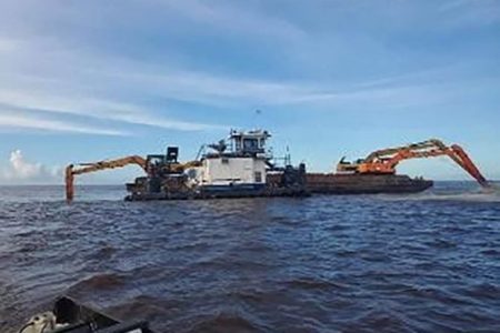 Excavators dredging the Pomeroon River mouth
