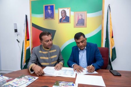 Guyana’s Chief Invest-ment Officer, Dr Peter Ramsaroop (left) and Chief Executive Officer of Pro-fessional Waste Solutions Inc. (PWSI), Mahendra Jettoo signing the investment agreement. (DPI photo)
