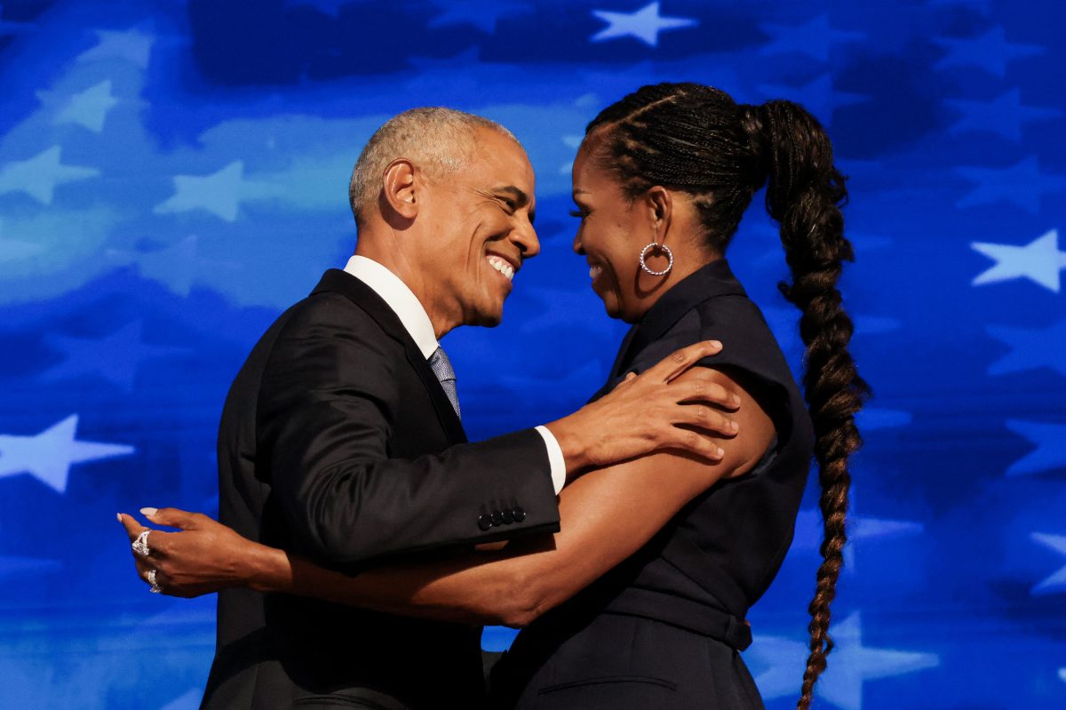 Former U.S. first lady Michelle Obama greets her husband, former U.S. President Barack Obama, on stage during Day 2 of the Democratic National Convention (DNC) in Chicago, Illinois, U.S., August 20, 2024. REUTERS/Alyssa Pointer