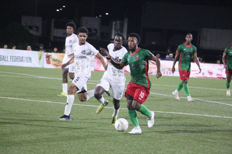 Kemar Beckford (no.10) of Slingerz trying to escape the pursuits of Bevney Marks of Santos
