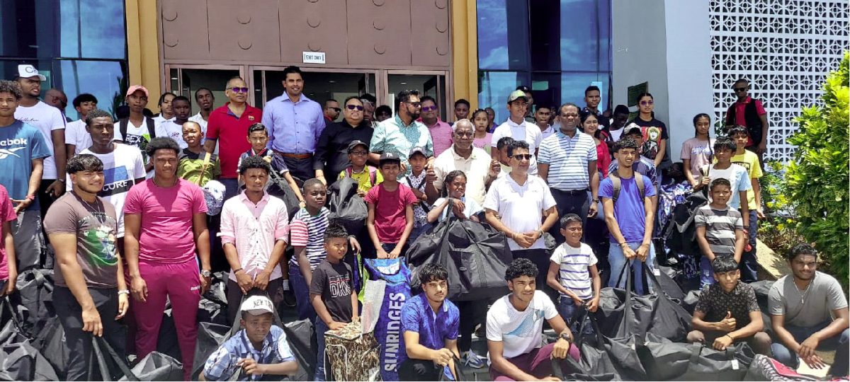 Academy players display the distributed cricket equipment that was donated by the Government of Guyana