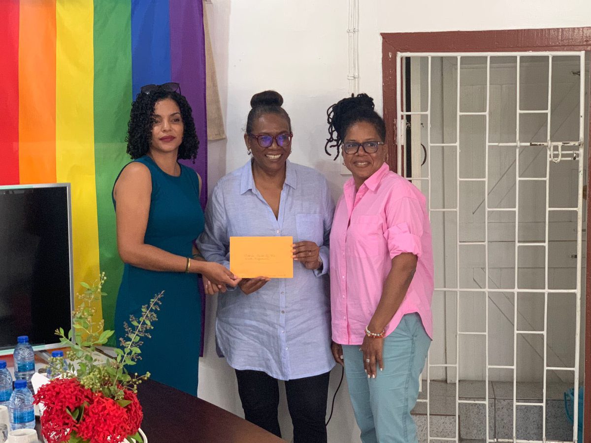 Ann Marie of North Rupununi Wildlife Club (left) receives a donation from Lisa Thompson and LouAnn Lewis Jackson