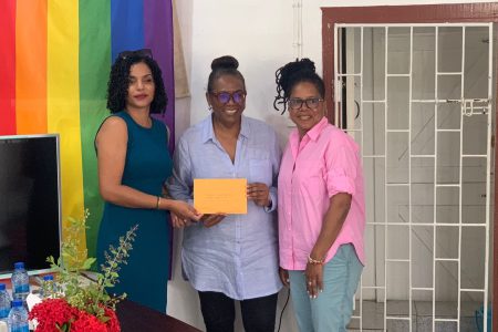 Ann Marie of North Rupununi Wildlife Club (left) receives a donation from Lisa Thompson and LouAnn Lewis Jackson