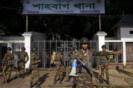 Security personnel stand guard next to a police station in Dhaka, Bangladesh, August 9, 2024. REUTERS/Fatima Tuj Johora