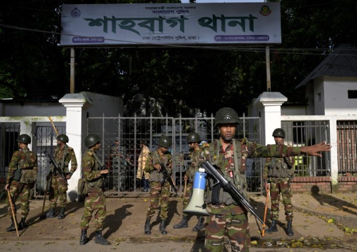 Security personnel stand guard next to a police station in Dhaka, Bangladesh, August 9, 2024. REUTERS/Fatima Tuj Johora