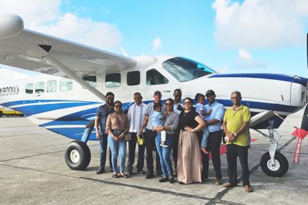 Brian Tiwarie Snr (third from left) poses with others in front of the plane