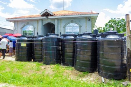 Some of the black tanks that were distributed to households for water storage in the Dr. Charles Housing Scheme 