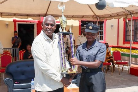 Minister of Home Affairs, Robeson Benn, hands over the Best Student trophy to Tiffany Caesar