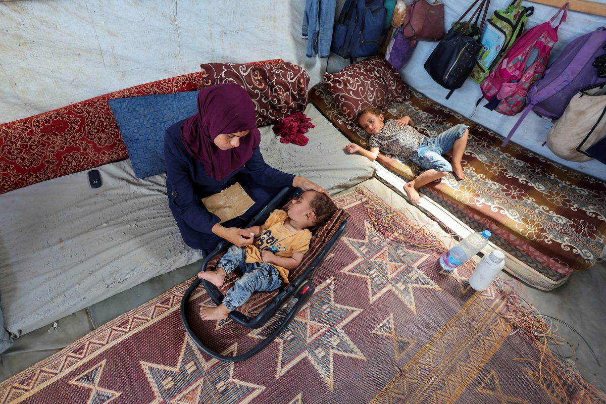 The mother of Palestinian boy Abdul Rahman Abu Al-Jidyan, who is the first person to contract polio in Gaza in 25 years, looks after him in their tent, in Deir Al-Balah, in the central Gaza Strip August 28, 2024. REUTERS/Ramadan Abed/File Photo