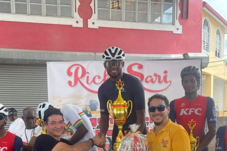 Jamual John receives his prizes from Carlos Rodrigues (right), son of the late Regan Rodrigues, in the presence of another relative