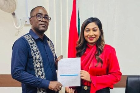 Dr. Mark Lyte, President GTU (left) and  Shannielle Hoosein-Outar, Permanent Secretary, MoE with the signed agreement